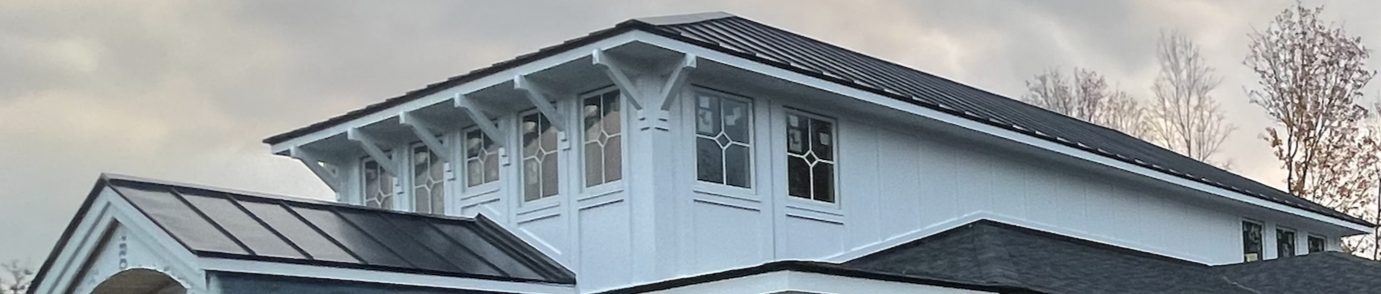 Standing seam metal roof and board-and-batten siding detail on a custom home